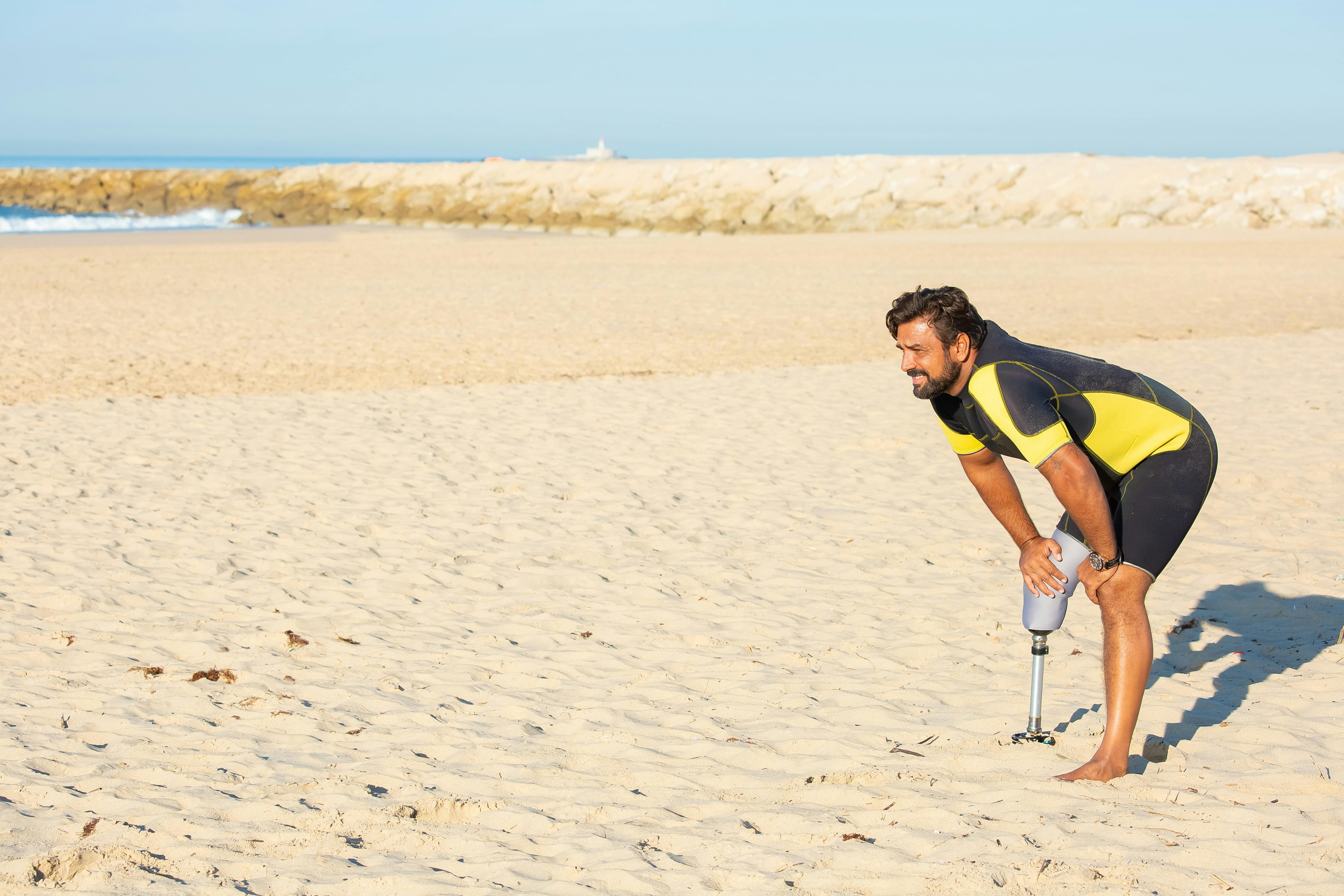 Tired sportsman amputee resting with hands on knees on beach \u00b7 Free ...