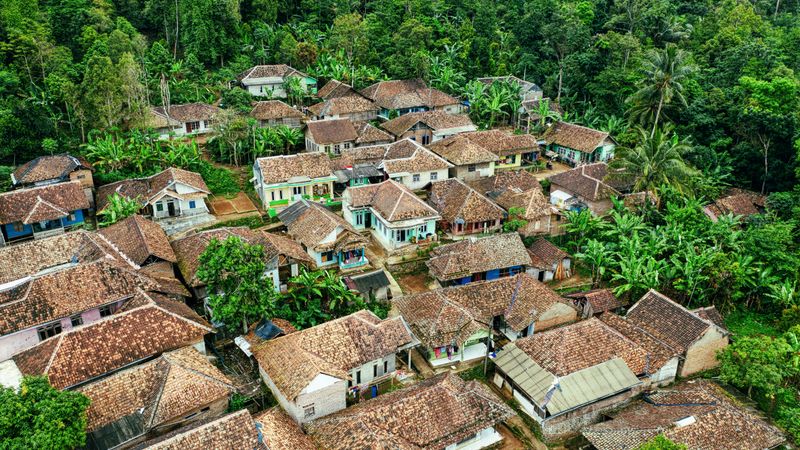 Wisata regeneratif di desa Indonesia dikelilingi hutan tropis dan pemukiman tradisional
