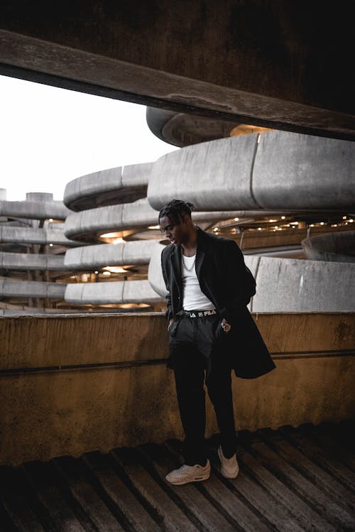 Calm young black male standing in multilevel parking lot building