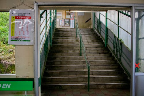 A Concrete Stairs with Green Metal Railings