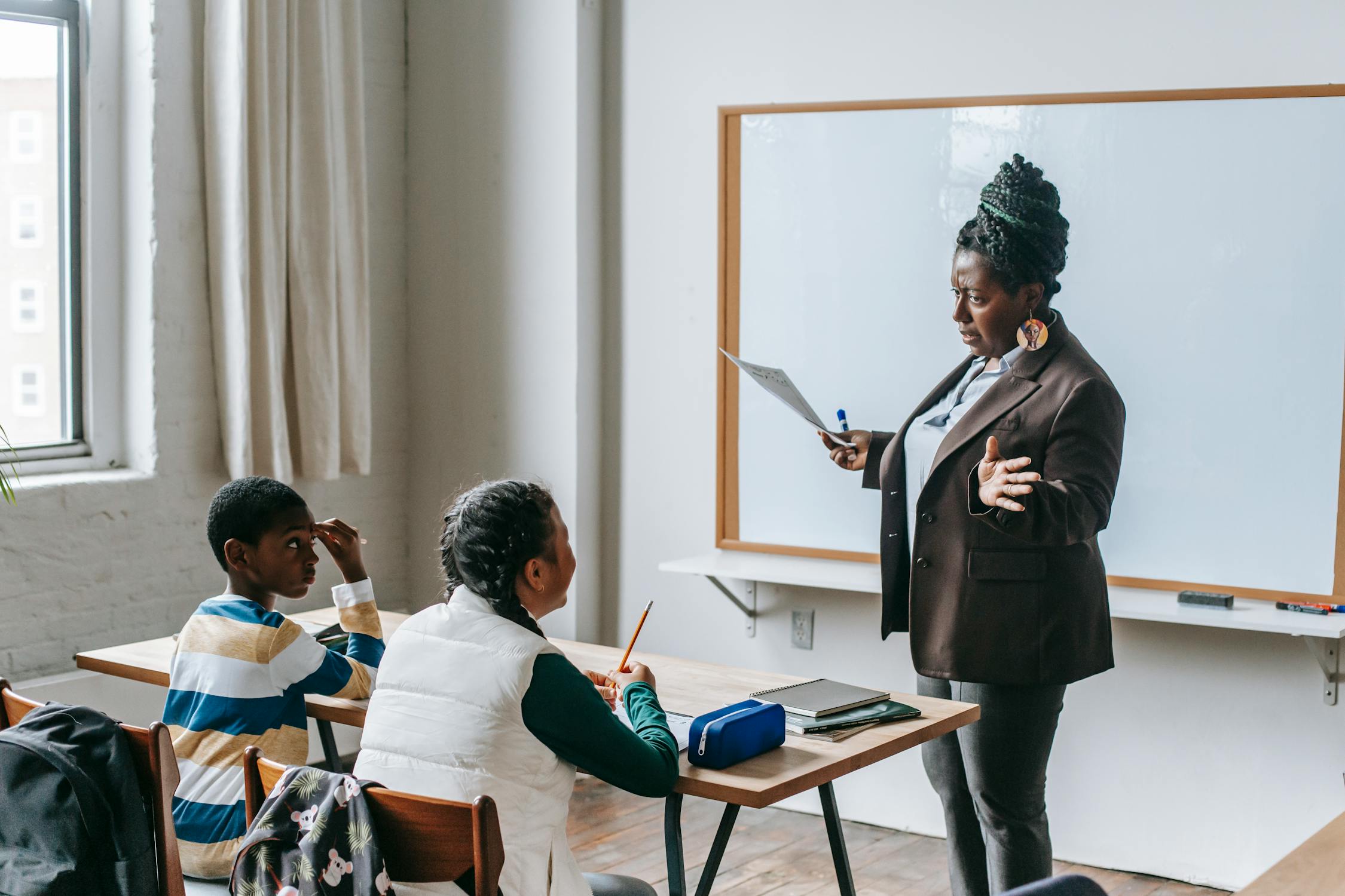 Black teacher explaining presentation to diverse elementary pupils Black teacher explaining presentation to diverse elementary pupils