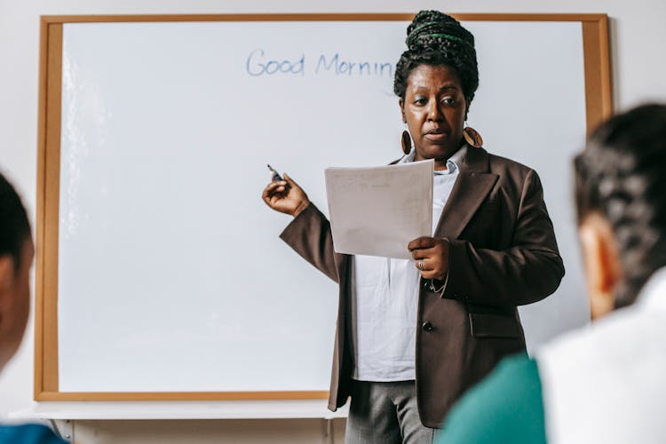 Focused Black Female Teacher Explaining Class Plan To Pupils