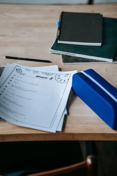 From above school desk with notebooks papers and pen case in light modern classroom