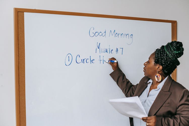 Black Female Teacher Writing On Whiteboard