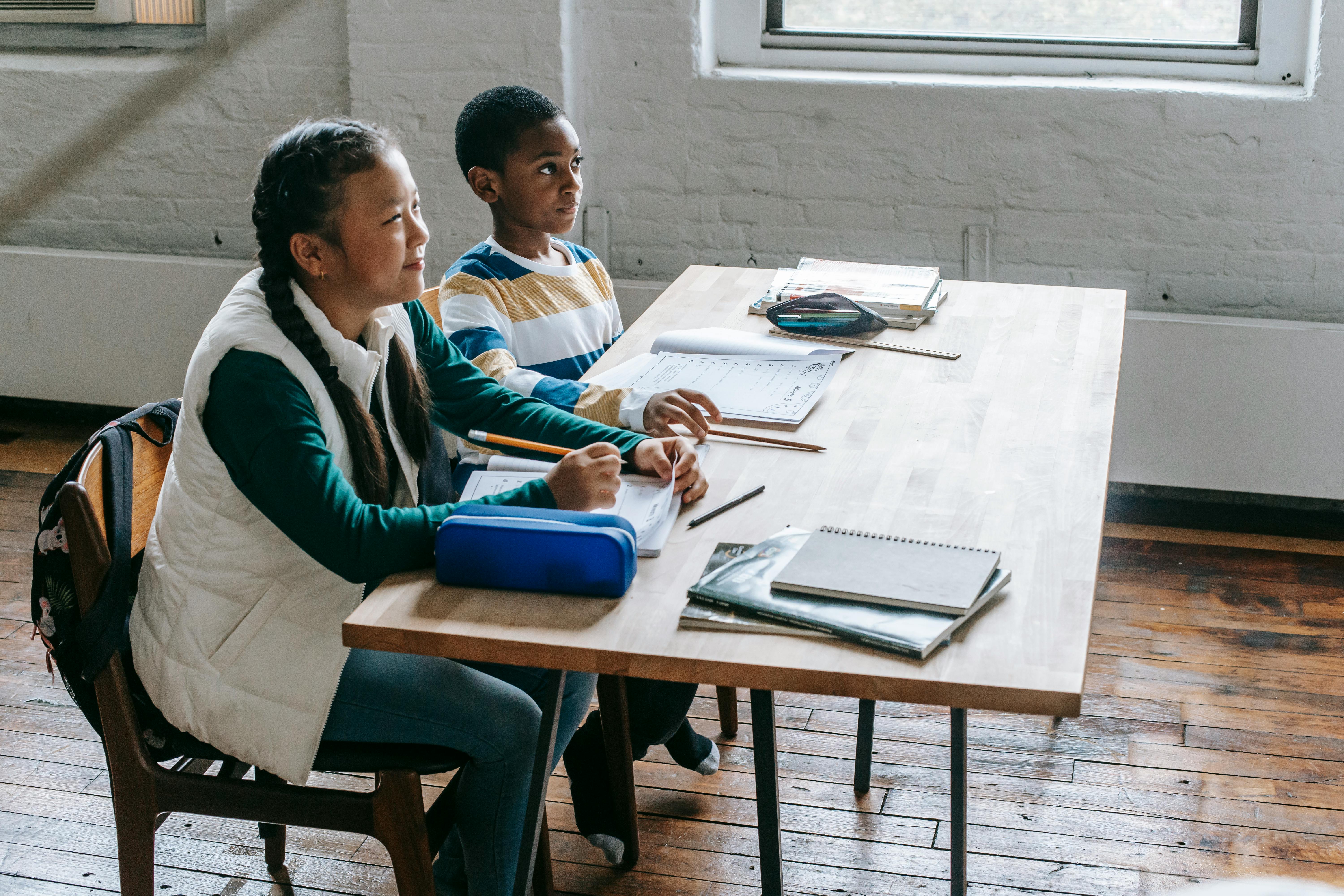 content diverse classmates sitting at desk in classroom