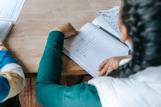 上课时，一位穿着休闲服的匿名女学生坐在课桌前，打开了字帖