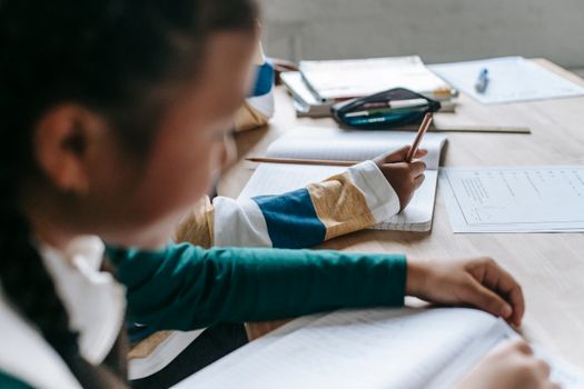 年轻的学生在教室的桌子上打开笔记本，专注于学业