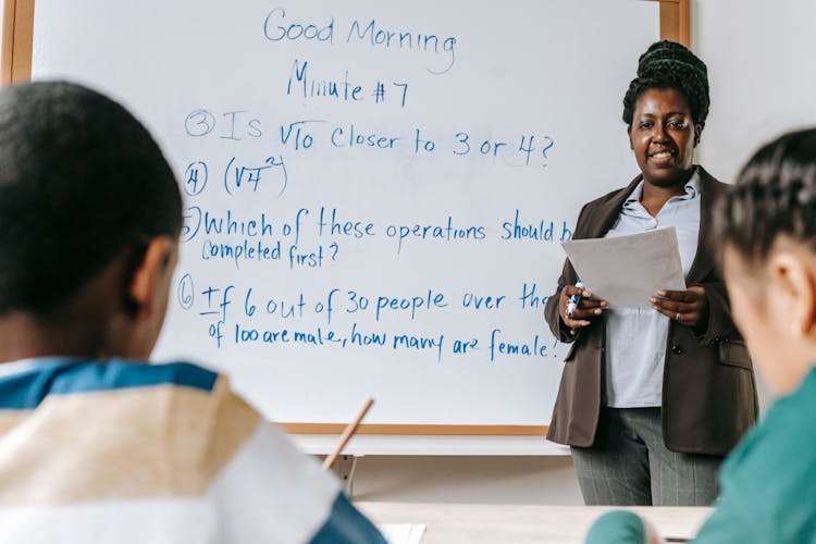 Content Black Math Teacher Talking To Diverse Pupils