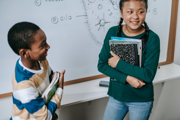 Happy Diverse Schoolchildren Standing Near Whiteboard In Classroom