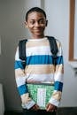 Smiling black child standing in classroom and looking at camera