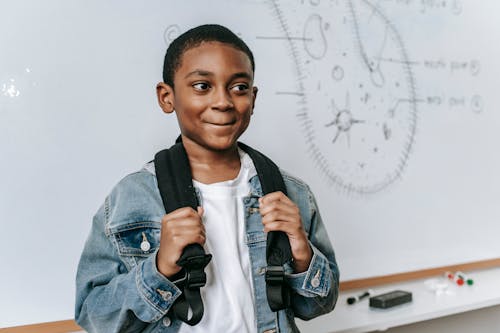 Ücretsiz Düzeni Ile Beyaz Tahta Yanında Neşeli Siyah çocuk Stok Fotoğraflar
