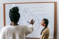 Diverse woman and teenager studying biology in classroom