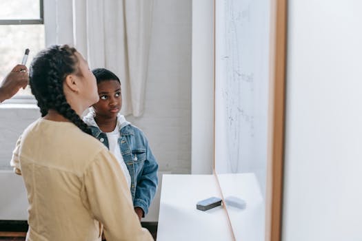 Two students attentively learning with a whiteboard in a modern classroom setting.