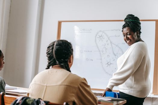 Black woman with students in classroom