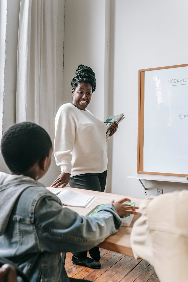 Black Woman With Pupil In Classroom