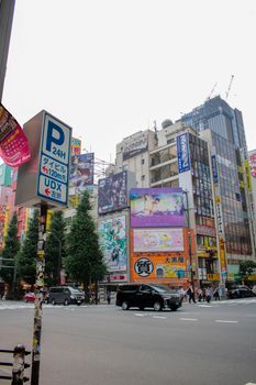 东京千代田市充满活力的街景中，广告牌和车流展现了城市生活的气息