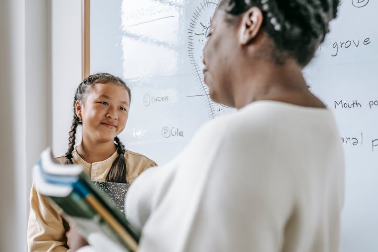 Happy Asian Student With Teacher In Classroom