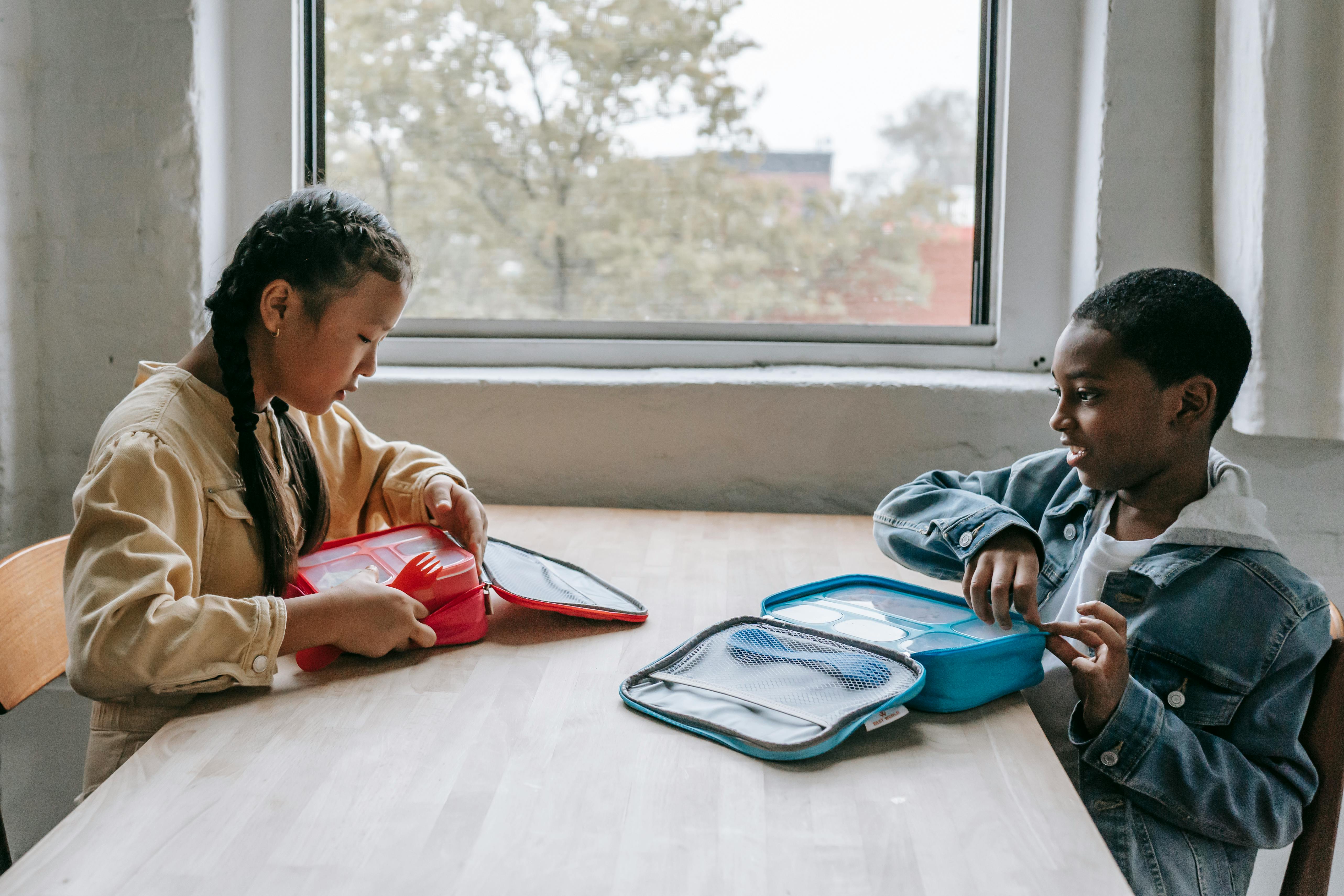 multiethnic classmates having lunch in classroom