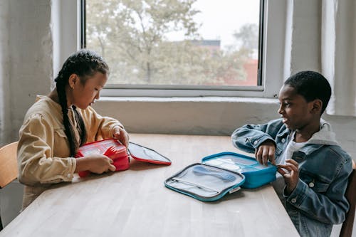 Free Multiethnic classmates having lunch in classroom Stock Photo