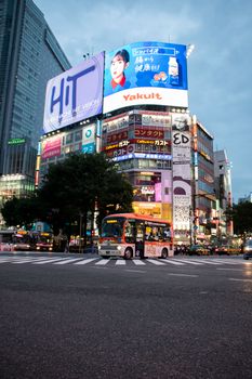 东京涩谷十字路口的夜间场景熙熙攘攘，明亮的广告牌与城市灯光交相辉映