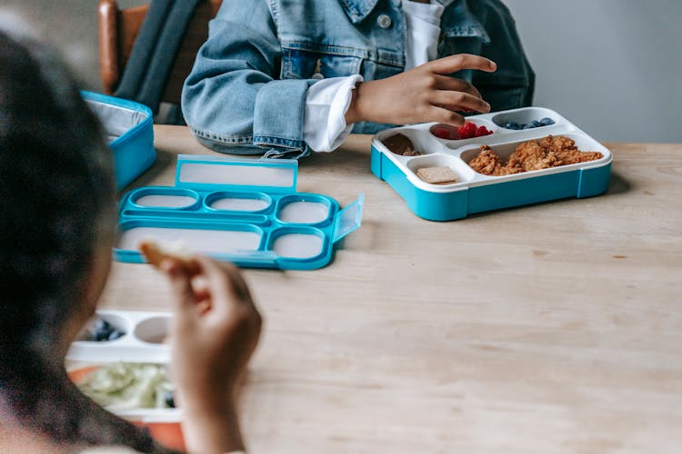 Crop Ethnic Children Eating Breakfast In School