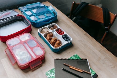 Free Lunch boxes with delicious food in classroom Stock Photo