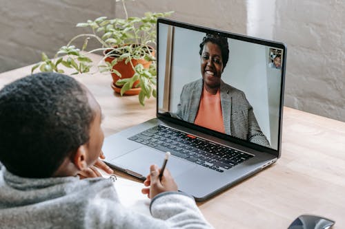 Black boy listening online lesson on laptop