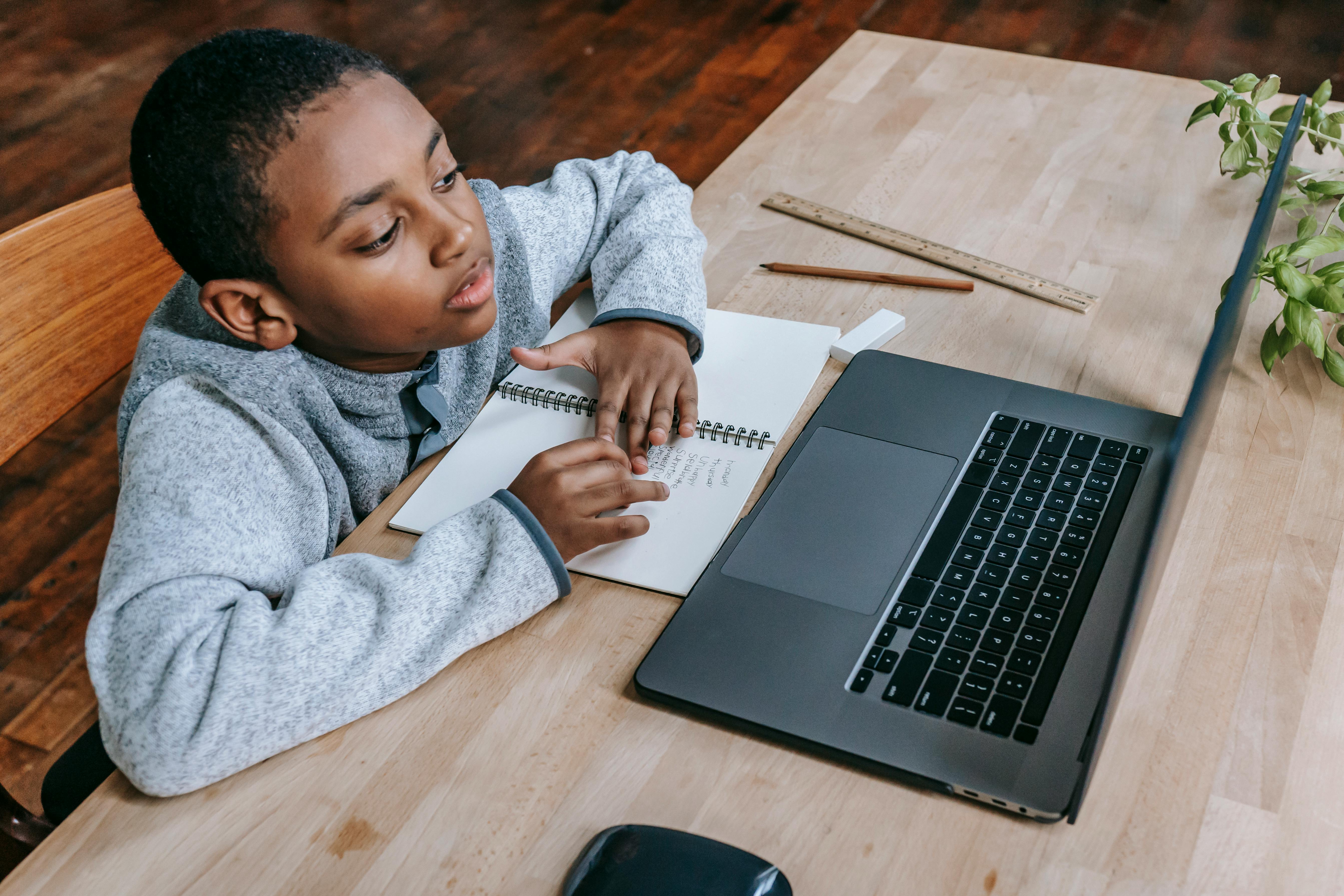 clever diligent black boy learning lessons online with laptop