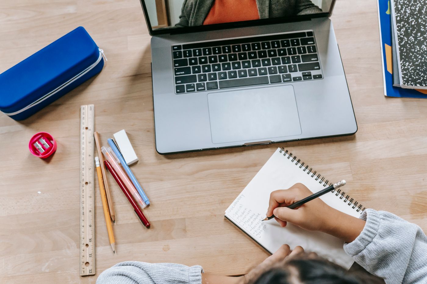 Computadora, cuaderno y lápices para planificar un producto digital propio