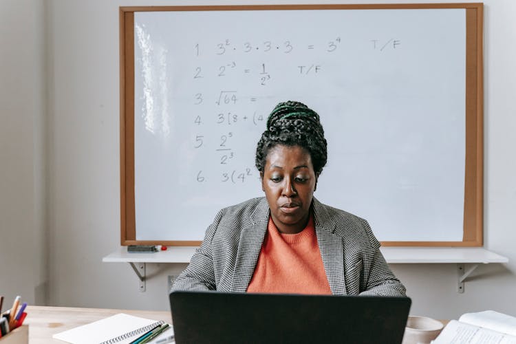 Serious Black Teacher Giving Mathematics Online On Laptop