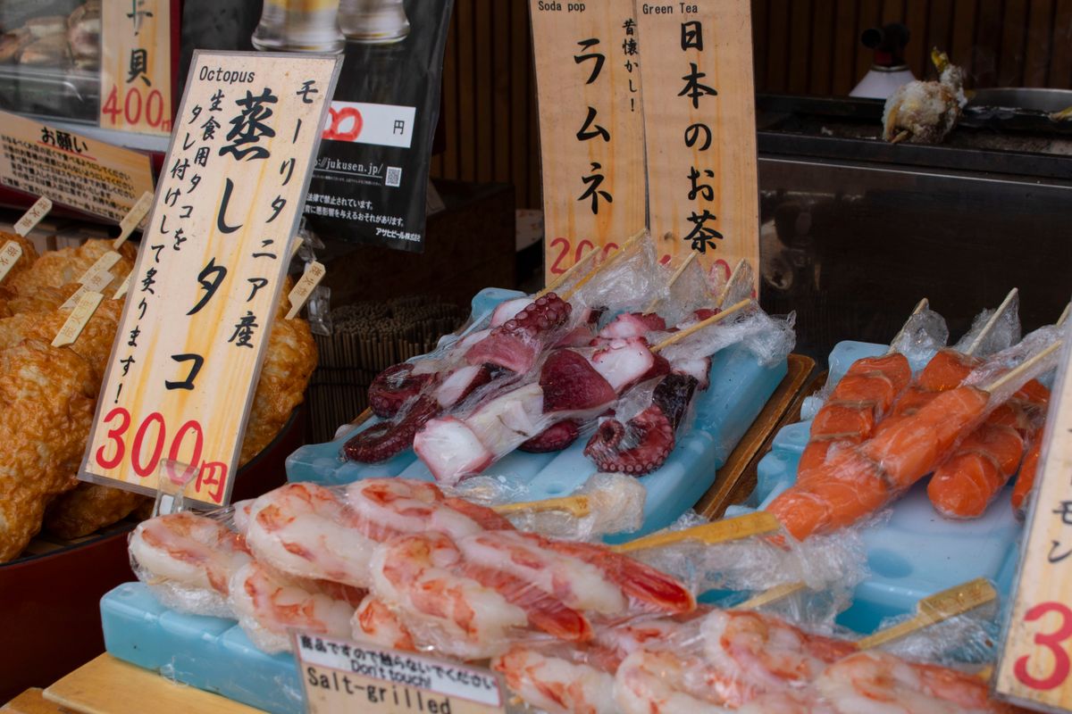 Colorful seafood skewers on display at a Japanese market with price tags