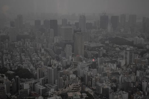 Aerial view of a foggy Tokyo cityscape showcasing skyscrapers and urban density.