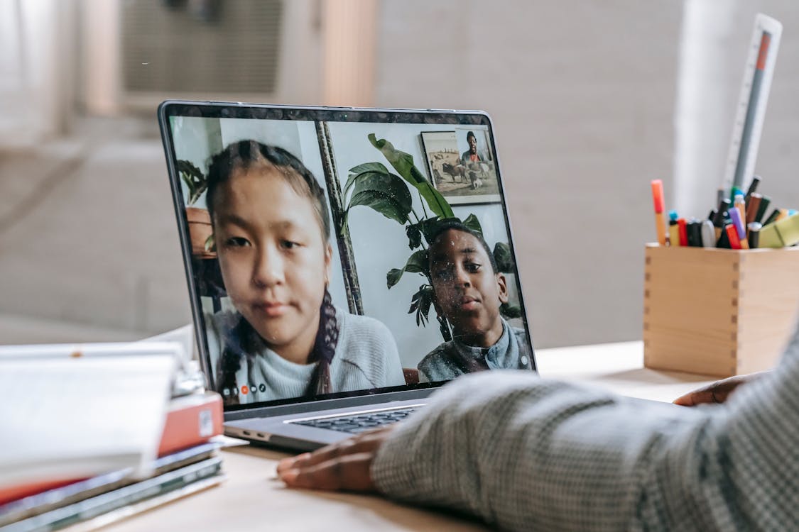 Free Black tutor making video call with pupils Stock Photo