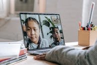 Black tutor making video call with pupils