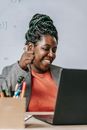 Delighted smart African American female showing thumb up after online exam on laptop