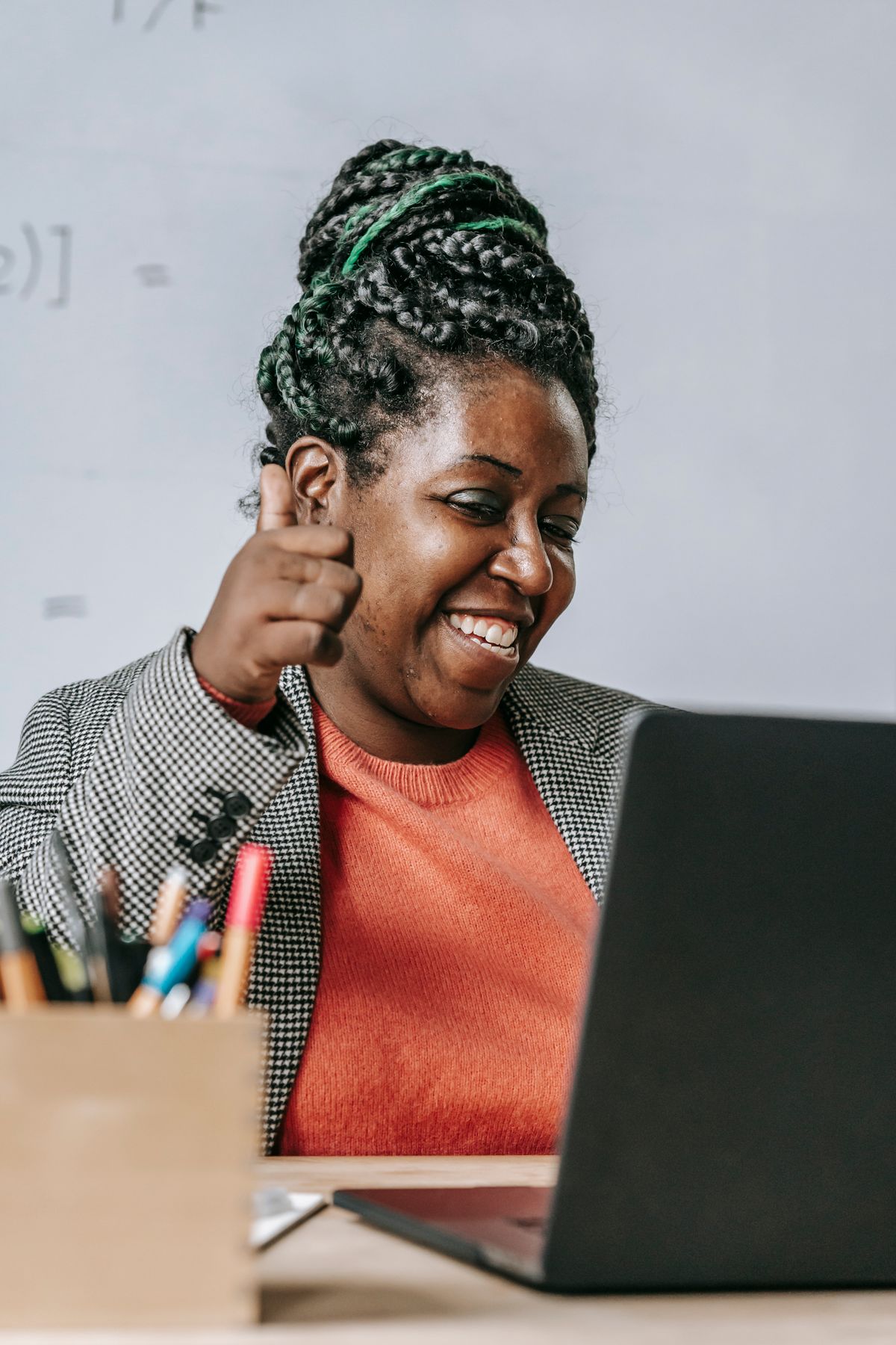 Woman celebrating progress after finishing an online Salesforce learning module on her laptop