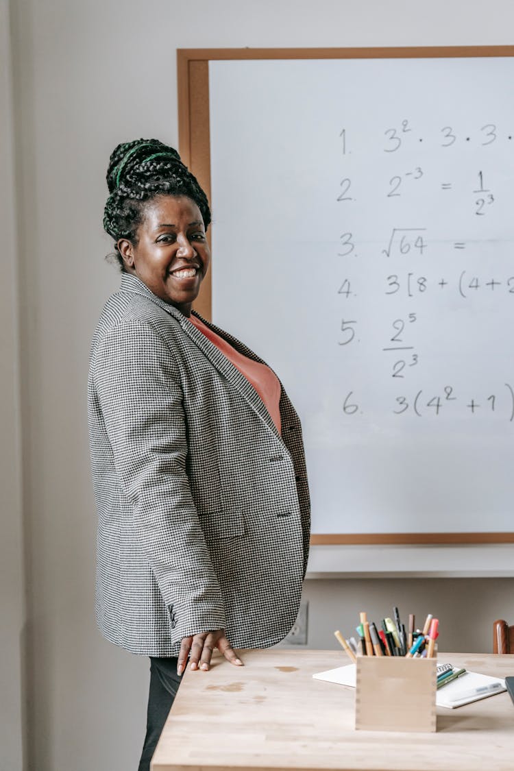 Cheerful Black Woman Preparing For Lesson In Classroom