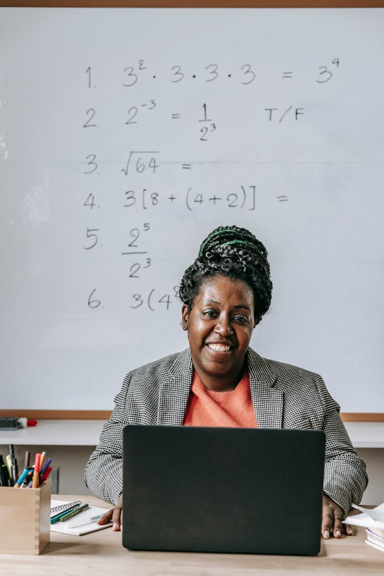 Positive Black Teacher Working With Laptop And Smiling