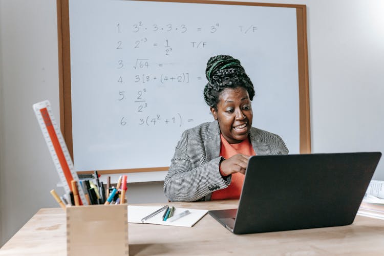 Excited Black Teacher Explaining Mathematics Online On Laptop