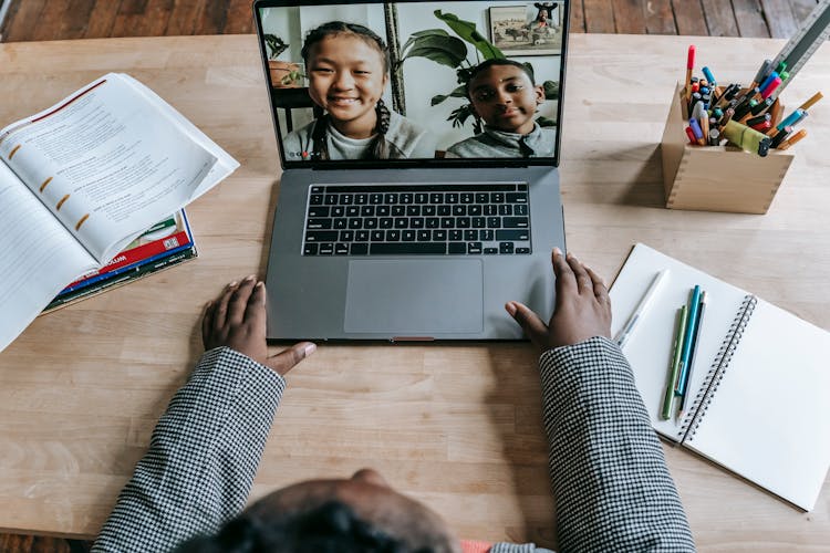 Black Teacher Using Laptop And Having Online Lesson With Pupils