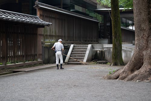 Man with Broom outside a Building