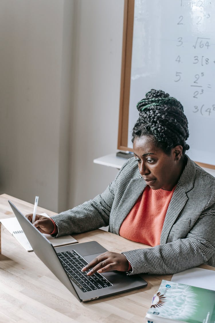 Black Woman Working On Laptop In Classroom