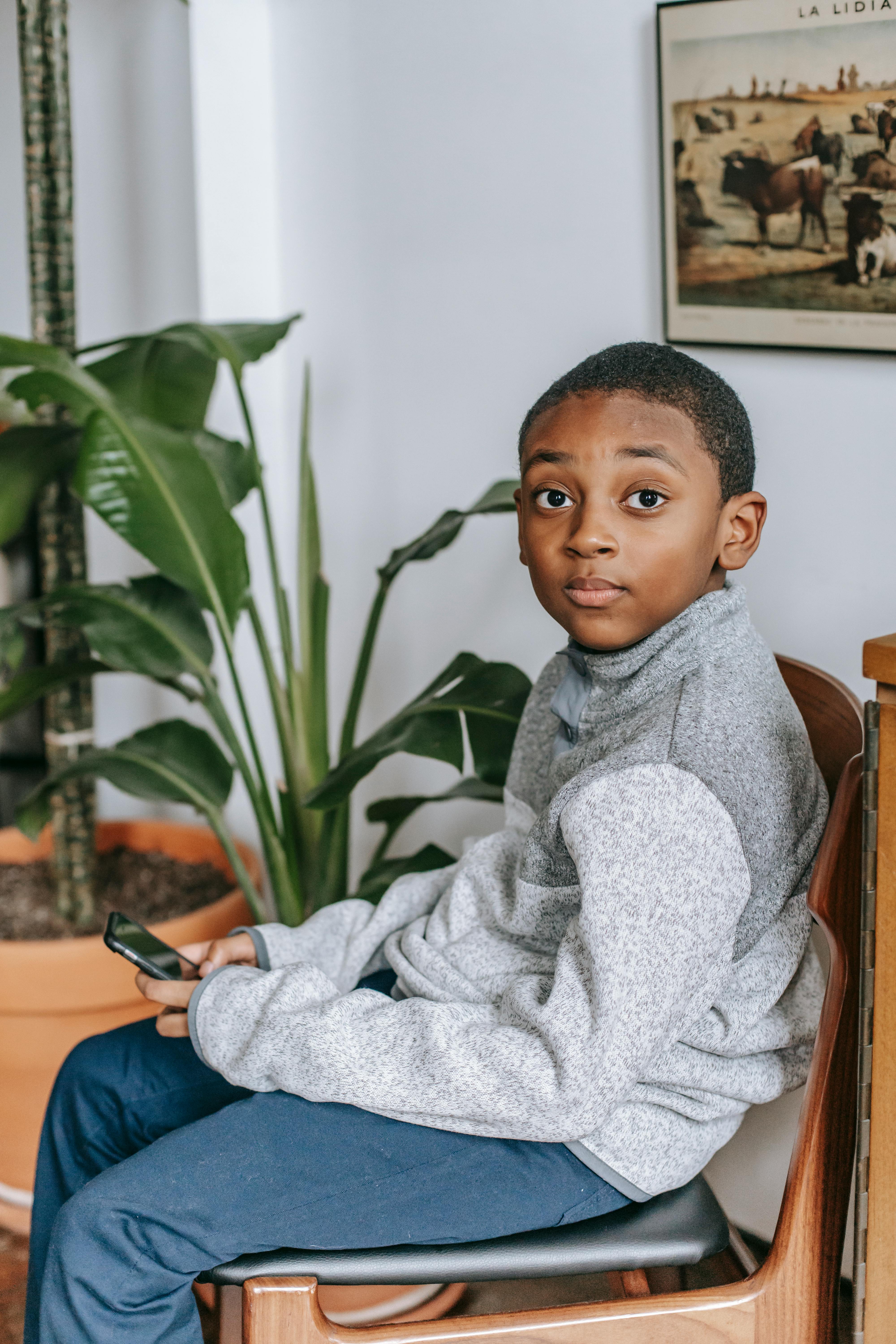 black boy on chair with smartphone