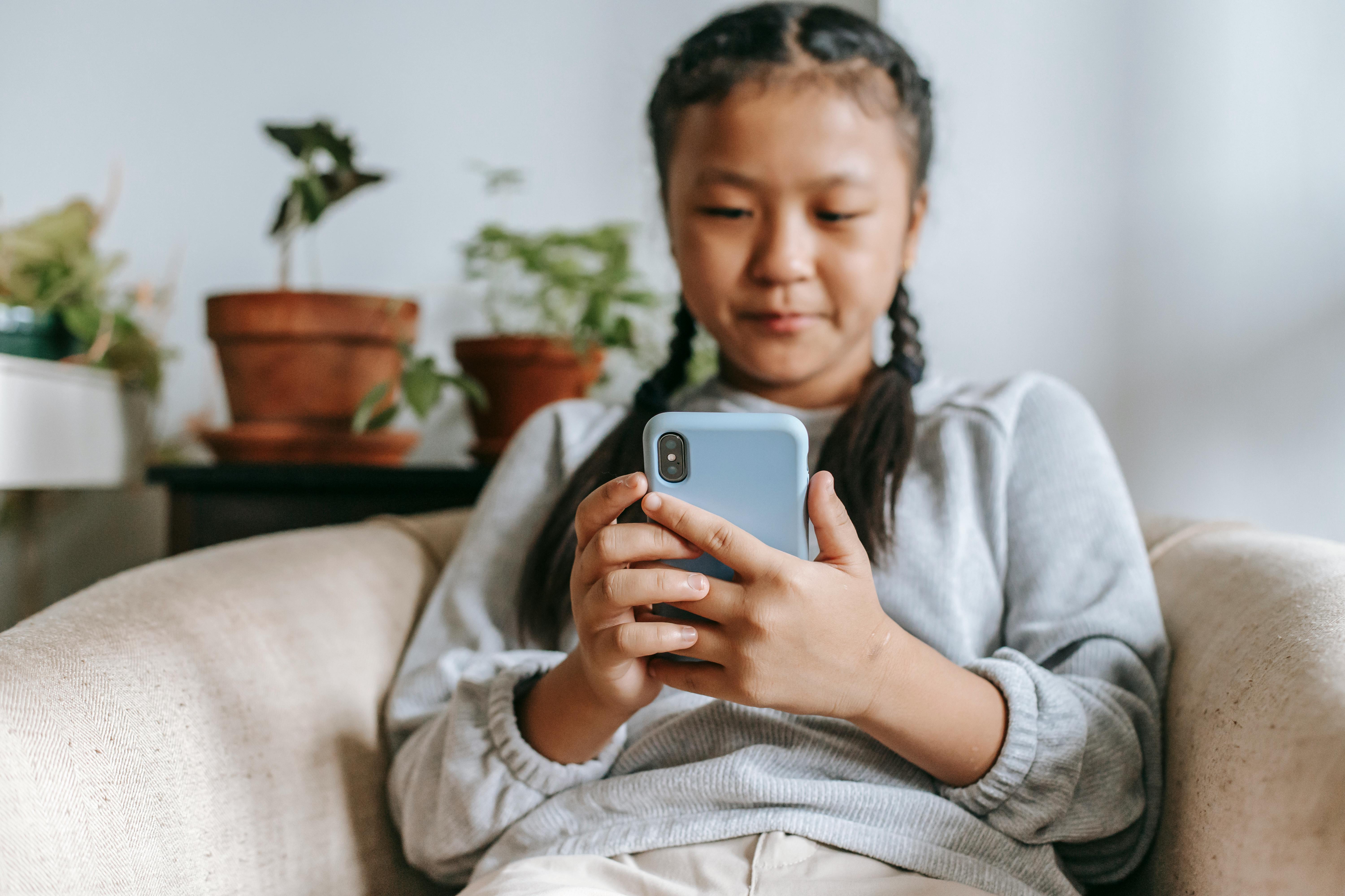 serious ethnic girl with smartphone