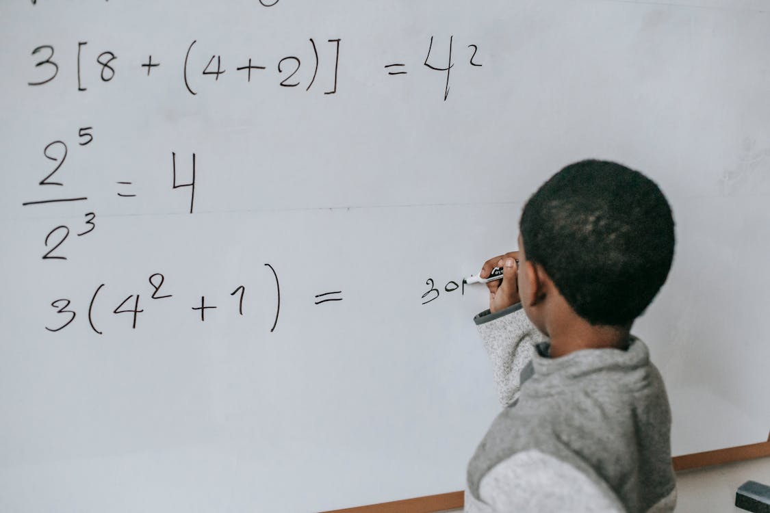 Concentrated black kid doing sums genius