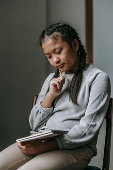 沉思的青少年在学校笔记本上写下想法，展现出深深的专注