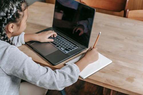 Studente Del Raccolto Che Prende Nota Dal Computer Portatile