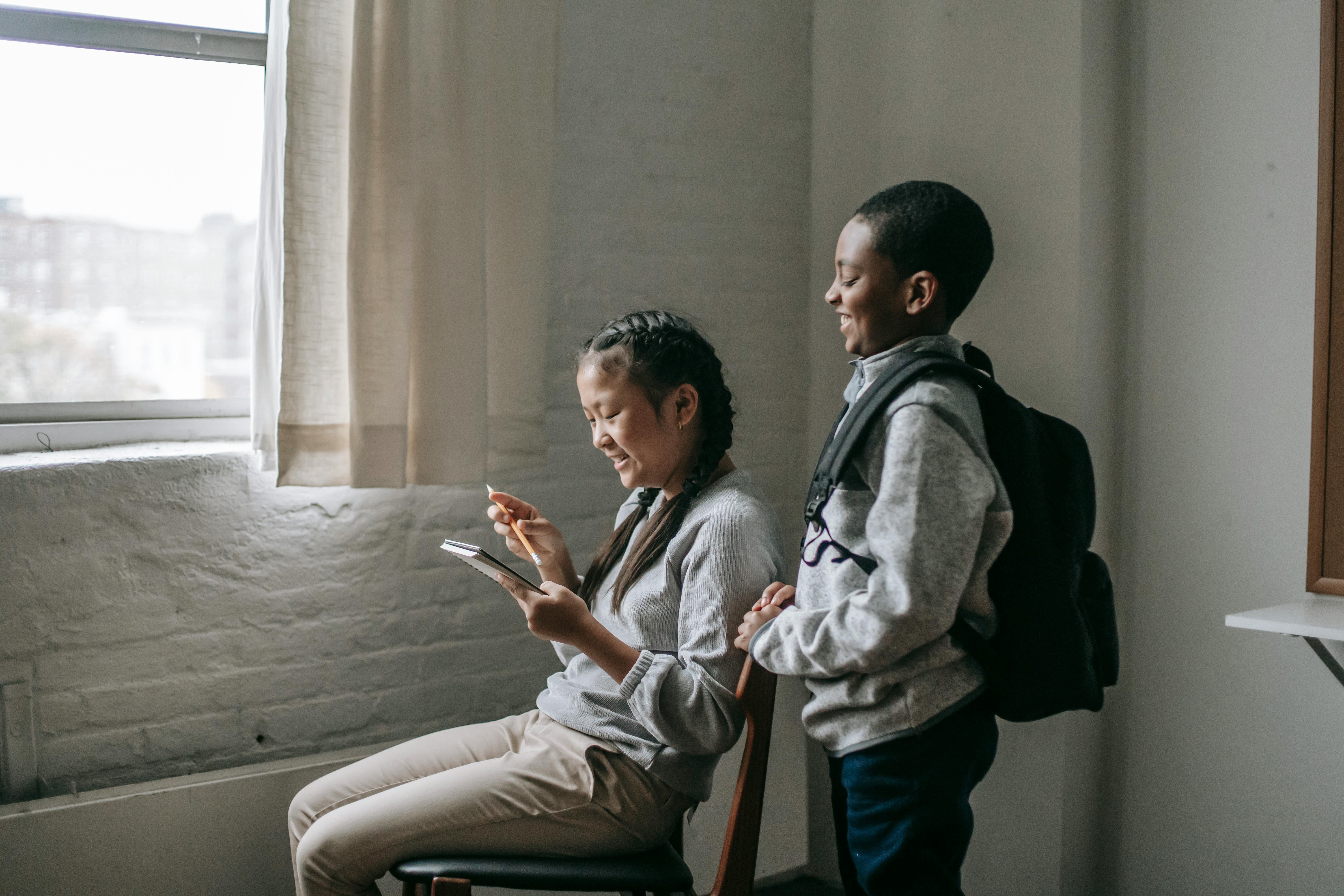 diverse school kids with notepad in classroom