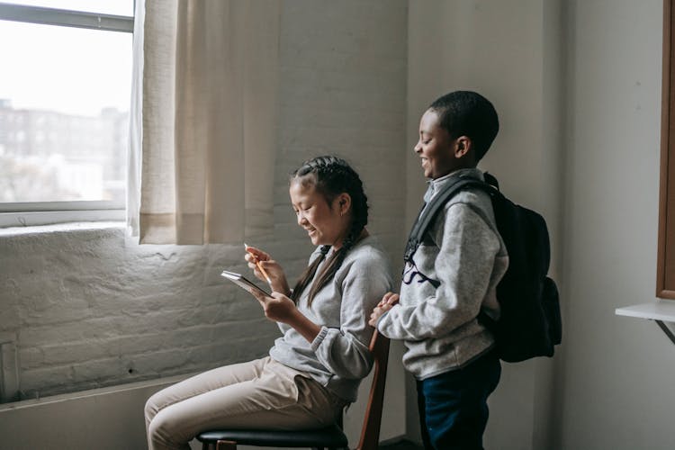 Diverse School Kids With Notepad In Classroom