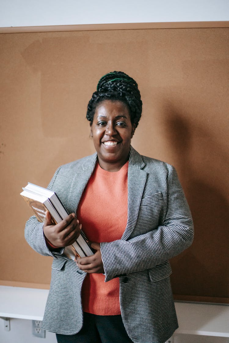 Smiling Black Female Teacher With Textbooks